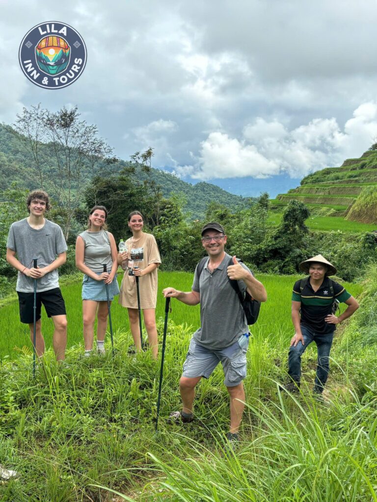 A couple standing on a hilltop, overlooking the stunning valley and mountains of Ha Giang.